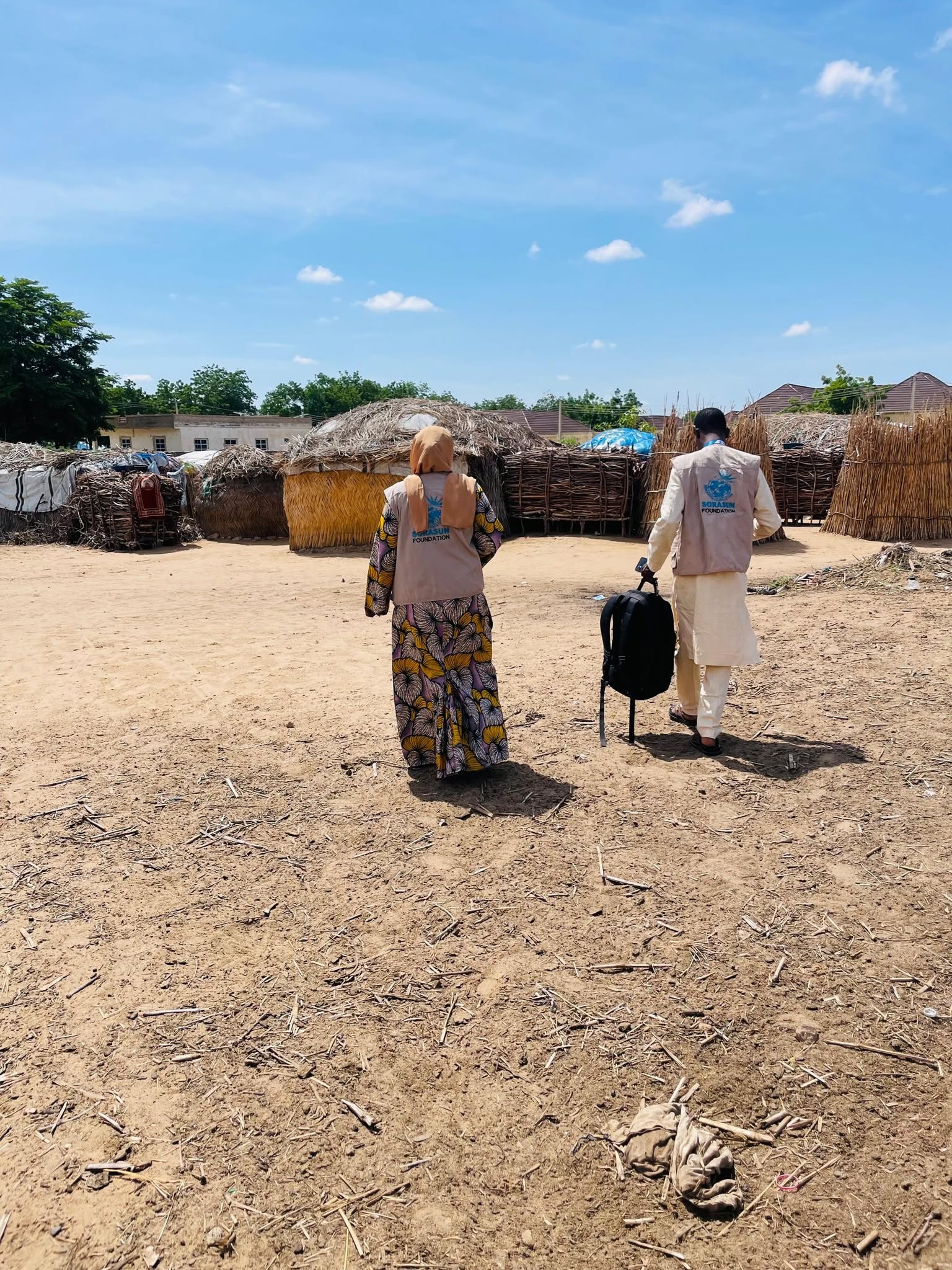 Field staff walking into a rural community